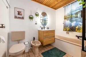 a bathroom with a toilet and a sink and a tub at Chalet BergMoment - by myNests in Rohrmoos +23 photos