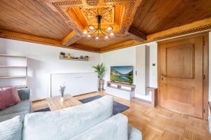 a living room with a couch and a wooden ceiling at Chalet BergMoment - by myNests in Rohrmoos
