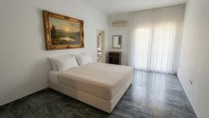 a bedroom with a bed and a painting on the wall at Kineta Prime Suites No6 in Kineta