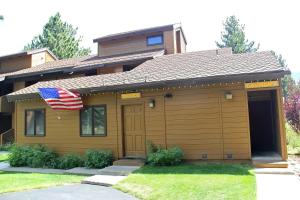 a house with an american flag in front of it at Mountain Condo | Spa Pool and Ski Shuttle Access in Mammoth Lakes