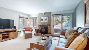 a living room with a couch and a tv at Mountain Condo | Spa Pool and Ski Shuttle Access in Mammoth Lakes