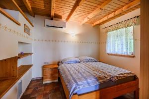 a bedroom with a bed and a dresser and a window at Holiday Home Marta with 4 Bedrooms in Raka