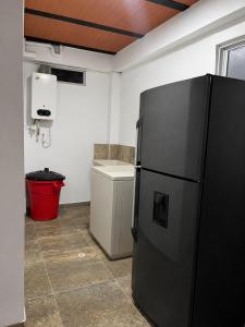 a kitchen with a black refrigerator in a room at Casa Hotel Villa María - Apia in Apía