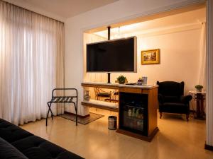 a living room with a flat screen tv on a wall at Cedro Hotel in Londrina