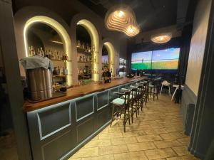 a bar in a restaurant with stools and a large screen at Paradise Apartments Solis in Batumi