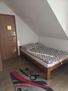 a small bed in a room with a rug at Gościnne Pieniny Pensjonat in Jaworki