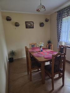 a dining room table and chairs with a pink table cloth at Gościnne Pieniny Pensjonat in Jaworki +9 photos