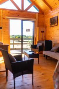 a living room with chairs and tables and a large window at Cabañas Isla del Mar in Constitución