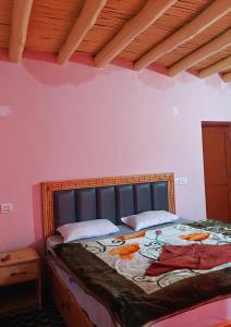 a bedroom with a bed with a wooden head board at Deachen Khangsar in Spangmik