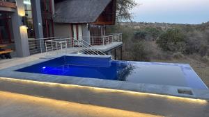 a large blue pool in front of a house at Ngong Hill, Mabalingwe in Warmbaths