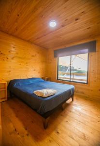 a bedroom with a bed in a wooden room at Cabañas Isla del Mar in Constitución +57 photos
