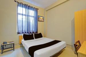 a bedroom with a bed and a window and a table at Super Hotel O AG Colony Park Patna Formerly Capital Pearl in Patna +34 photos