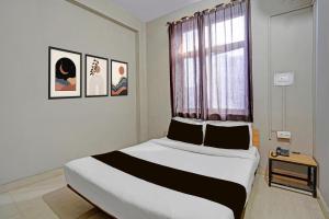 a bedroom with a large bed with a window at Super Hotel O AG Colony Park Patna Formerly Capital Pearl in Patna