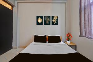 a bedroom with a large white bed with two pillows at Super Hotel O AG Colony Park Patna Formerly Capital Pearl in Patna