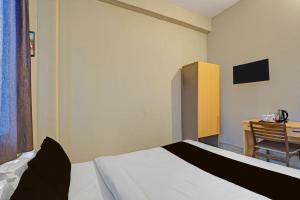a bedroom with a bed and a desk with a television at Super Hotel O AG Colony Park Patna Formerly Capital Pearl in Patna