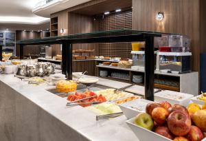a buffet line with fruits and vegetables on display at Hotel D'sintra in Balneário Camboriú