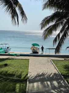 a person standing next to a boat on the beach at Oceana Trinco in Trincomalee +5 photos
