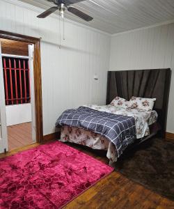 a bedroom with a bed and a pink rug at JJK free Breakfast in Barberton