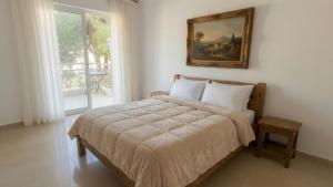 a bedroom with a bed with a picture on the wall at Kineta Prime Suites No8 in Kineta