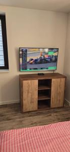 a flat screen tv sitting on top of a wooden entertainment center at Apartament WLA in Barcice