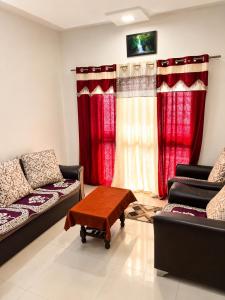 a living room with two couches and red curtains at Elite Nest Stay in Nashik