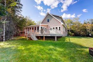 a large house with a porch and a yard at Dog-friendly, bayfront home w/rocky beach, full kitchen, washer/dryer & firepit in Gouldsboro +19 photos