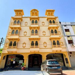a building with a car parked in front of it at Hotel Shree Banke Bihari Heritage in Maheshwar