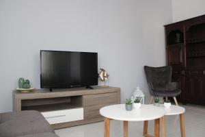 a living room with a flat screen tv on a wooden entertainment center at Casa Crisel in Aljezur