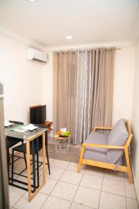 a living room with a desk and a chair and a table at Direl Lodge in Libreville