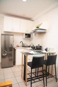 a kitchen with white cabinets and a stainless steel refrigerator at Direl Lodge in Libreville