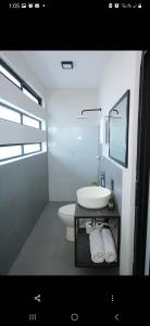 a white bathroom with a sink and a toilet at Lailinn Serenity in Santa Cruz Xoxocotlán
