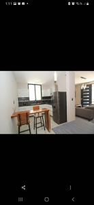a kitchen and living room with a table and a refrigerator at Lailinn Serenity in Santa Cruz Xoxocotlán +15 photos