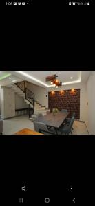 a dining room with a table and a stone wall at Lailinn Serenity in Santa Cruz Xoxocotlán