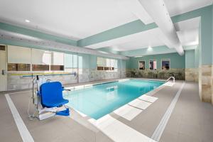a swimming pool with a blue chair in the middle at Hampton Inn & Suites By Hilton Knightdale Raleigh in Raleigh