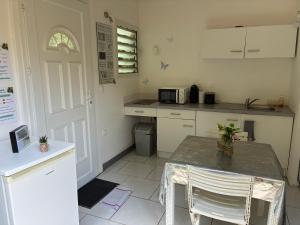 a kitchen with a counter and a table with chairs at Éclat doasis in Vieux-Habitants