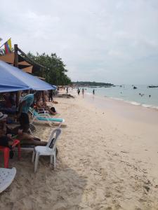 a group of people sitting on a beach at Venido del mar beach in Cartagena de Indias