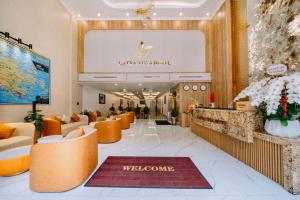 a lobby of a hotel with orange chairs and a welcome sign at Cat Ba Vista Luxury Hotel - New 2026 - Rooftop Infinity Pool in Cat Ba +144 photos