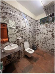 a bathroom with a toilet and a sink at Aetheria Estate Retreat in Chikmagalūr
