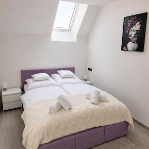 a bedroom with a large bed with towels on it at Grafitowe Apartamenty in Czarna Góra