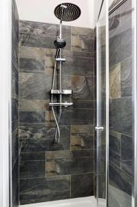 a shower with a shower head in a bathroom at Scandi Lux retreat in Stockholm
