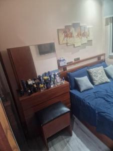 a bedroom with a blue bed and a chair at apparemment wifaq in Temara