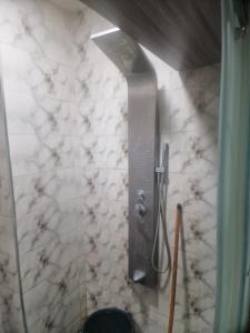 a shower in a bathroom with a marble wall at apparemment wifaq in Temara