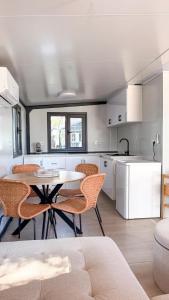 a kitchen with a table and chairs in a room at Chalet met grote tuin en privé jacuzzi in Wijdenes