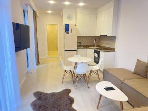 a living room with a couch and a table and chairs at Paradise Apartments Solis in Batumi