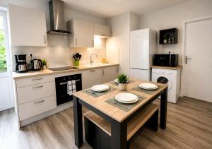 a kitchen with a wooden table with plates on it at Appart'Hôtel Entre les 2 Roches in Prissé +58 photos