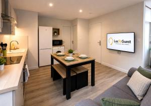 a kitchen and a living room with a table at Appart'Hôtel Entre les 2 Roches in Prissé