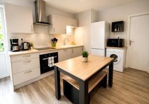 a kitchen with a wooden table and a sink at Appart'Hôtel Entre les 2 Roches in Prissé