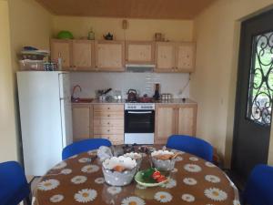 a kitchen with a table and chairs and a kitchen with a refrigerator at Cozy Mountain Chalet Bakhmaro in Chʼkhakoura