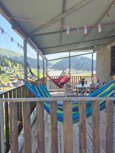 a porch with two hammocks and a table and chairs at Cozy Mountain Chalet Bakhmaro in Chʼkhakoura +12 photos