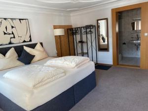 a bedroom with a large bed and a bathroom at Goldener Adler  +12 photos